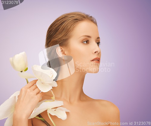 Image of beautiful young woman with orchid flowers