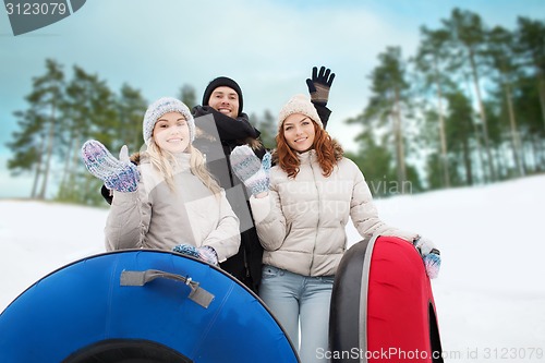 Image of group of smiling friends with snow tubes