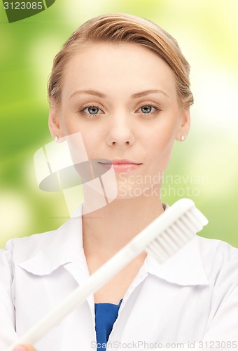 Image of happy young female dentist with tooth brush