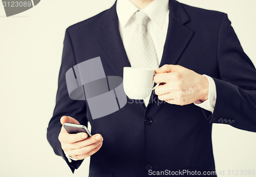 Image of man with smartphone and cup of coffee