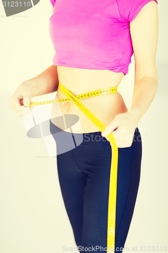 Image of trained belly with measuring tape