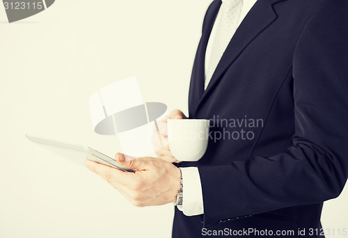 Image of man with tablet pc and cup of coffee