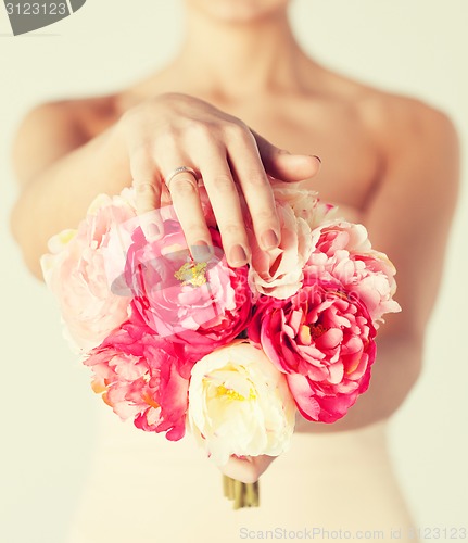 Image of bride with bouquet of flowers and wedding ring