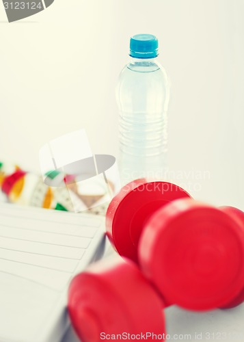 Image of scales, dumbbells, bottle of water, measuring tape