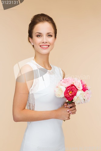 Image of smiling woman in white dress with bouquet of roses