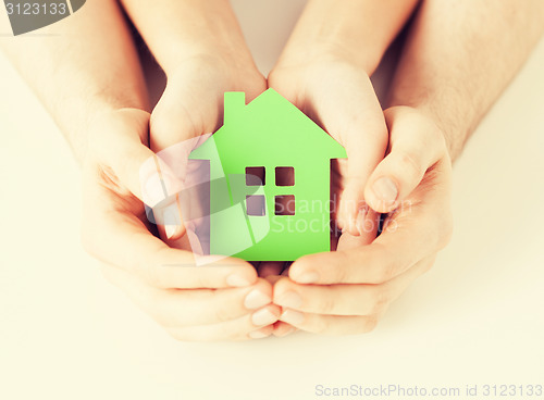 Image of couple hands holding green house