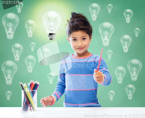 Image of happy school girl drawing with coloring pencils