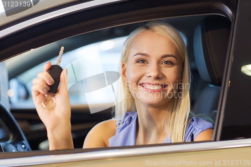 Image of happy woman getting car key in auto show or salon