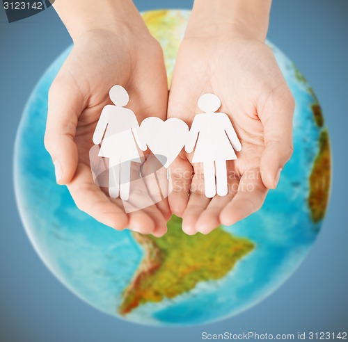 Image of female hands with paper gay couple figures