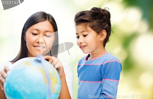 Image of happy mother and daughter with globe