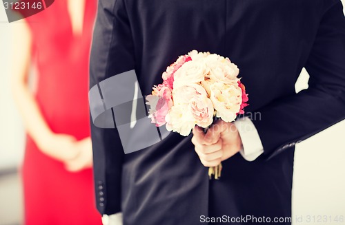 Image of man hiding bouquet of flowers