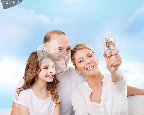 Image of happy family with camera at home