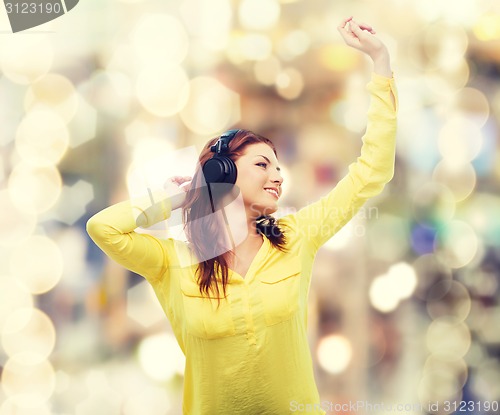 Image of teenage girl sitting on sofa with headphones