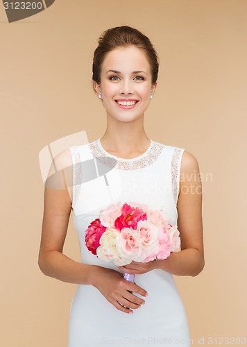 Image of smiling woman in white dress with bouquet of roses