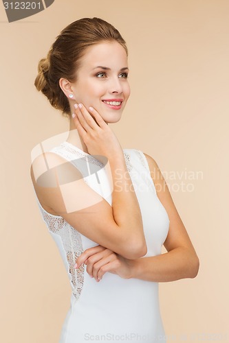 Image of smiling woman in white dress with diamond ring