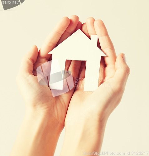 Image of woman hands with paper house