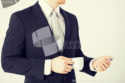 Image of man with smartphone and cup of coffee