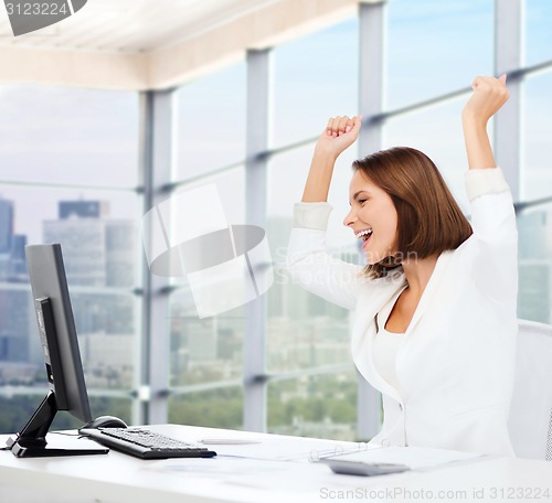Image of happy businesswoman with computer in office