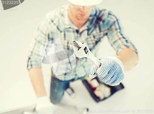 Image of man with ladder, toolkit and spanner
