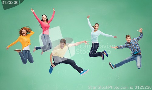 Image of group of smiling teenagers jumping in air