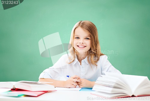 Image of happy girl with books and notebook at school