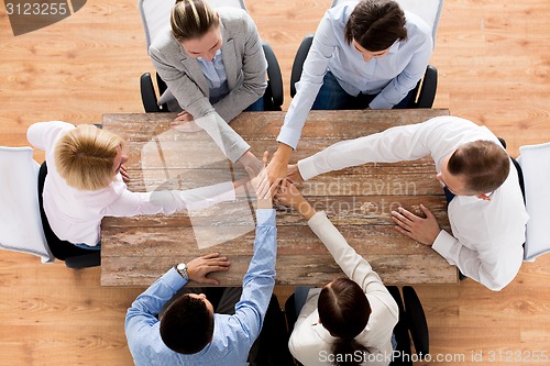 Image of close up of business team with hands on top