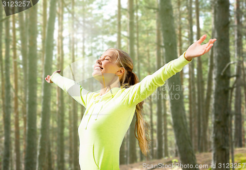 Image of happy woman in sport clothes raising hands