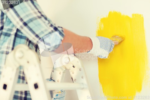 Image of close up of male in gloves holding paintbrush