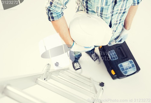 Image of man with ladder, helmet and toolkit