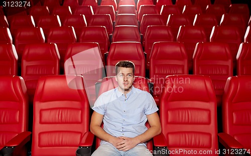 Image of happy young man watching movie in theater