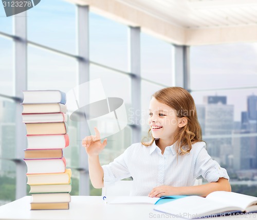 Image of happy girl with books and notebook at school