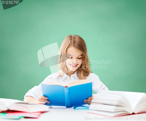 Image of happy student girl reading book at school