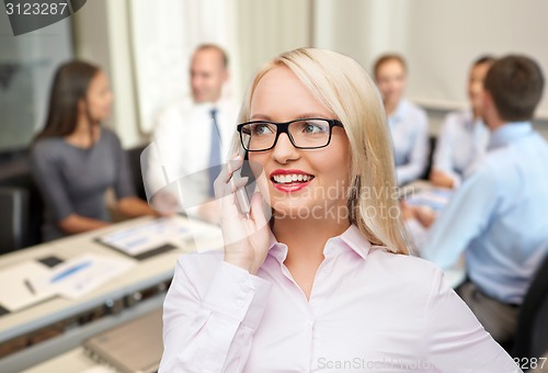 Image of smiling businesswoman calling on smartphone