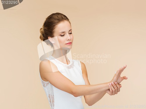 Image of smiling woman in white dress with diamond ring