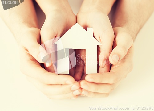 Image of woman and hands with paper house