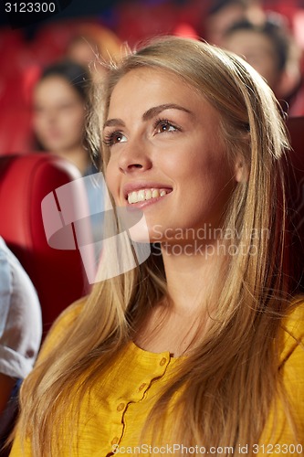 Image of happy young woman watching movie in theater