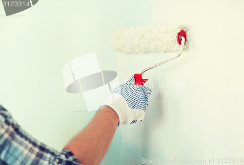 Image of close up of male in gloves painting wall
