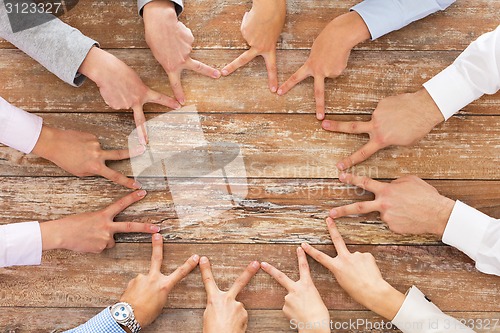 Image of close up of business team showing victory gesture