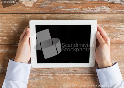 Image of close up of female hands with tablet pc on table