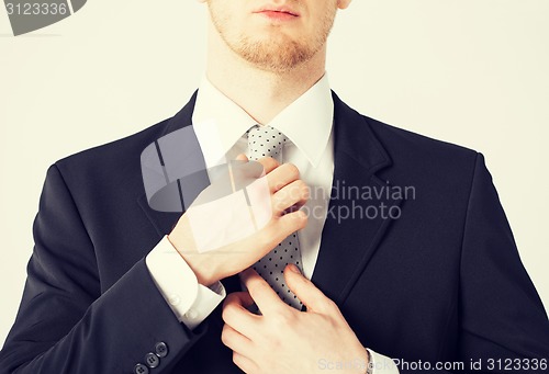 Image of man adjusting his tie