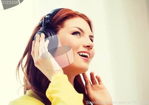 Image of smiling young girl in headphones at home