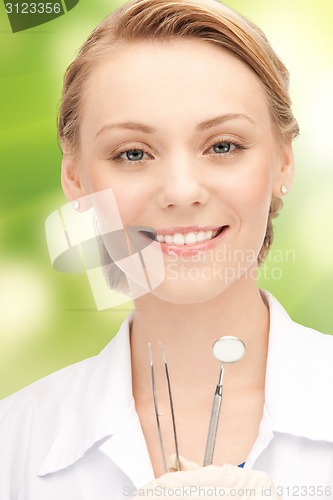 Image of happy young female dentist with tools