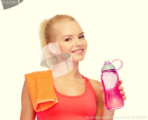 Image of smiling sporty woman with water bottle and towel