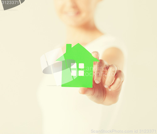 Image of woman hands holding green house