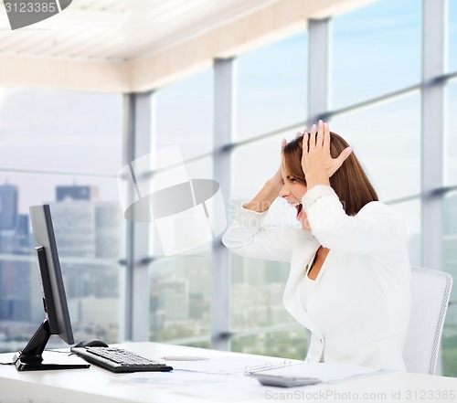 Image of businesswoman screaming in front of computer