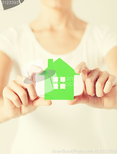 Image of woman hands holding green house