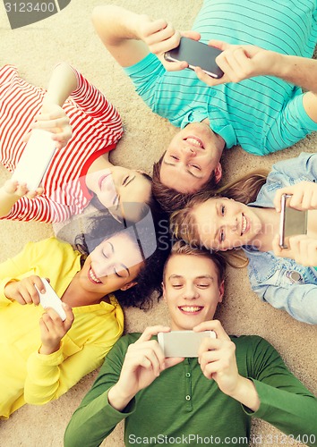 Image of group of smiling people lying down on floor