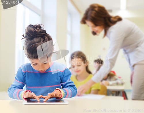 Image of little school girl with tablet pc over classroom