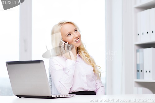 Image of smiling businesswoman calling on smartphone