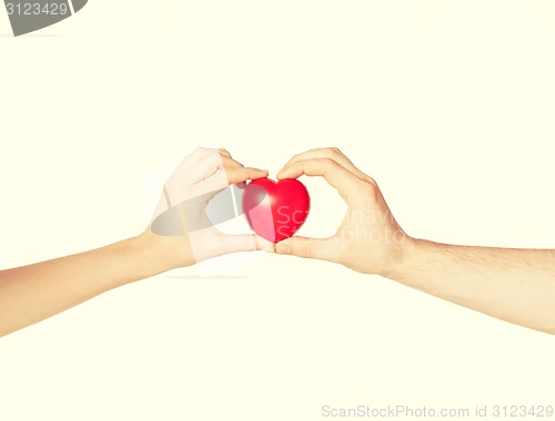 Image of woman and man hands with heart
